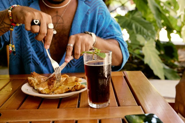 An image of a woman cutting food on a plate