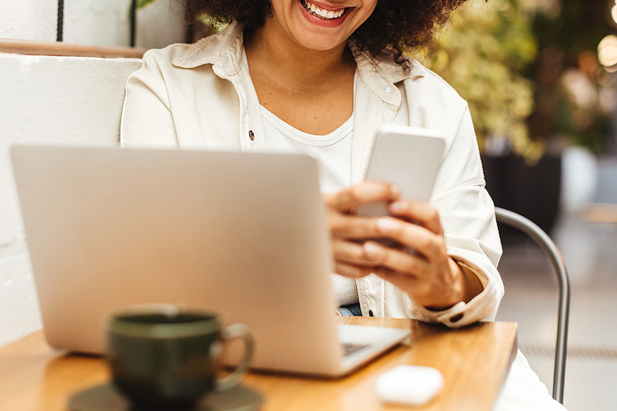 An image of a woman on the phone in front of a laptop