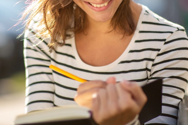 An image of a woman writing in a book