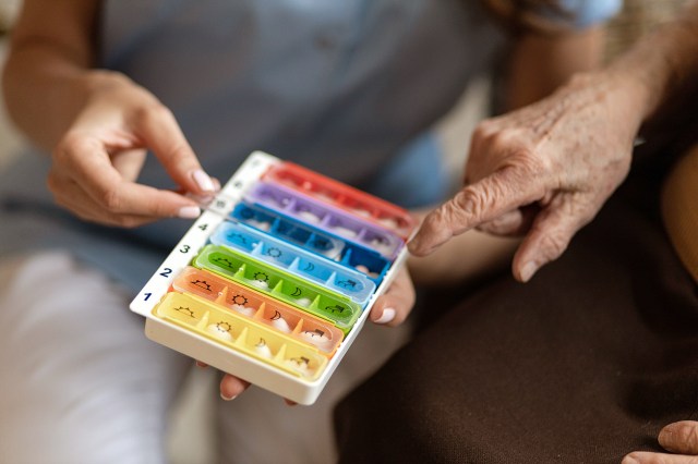 An image of a person holding a pill box