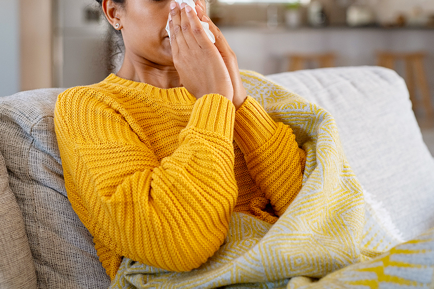 An image of a woman blowing her nose