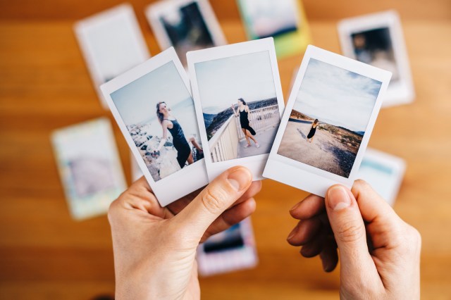 An image of a person holding Polaroid photographs