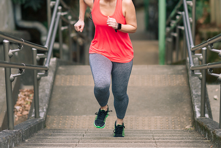 An image of a woman running up stairs