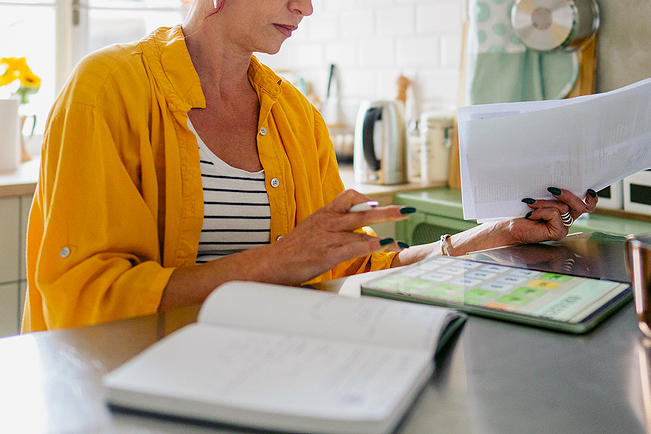 An image of a woman sitting at a desk with paperwork