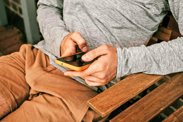 Person on bench looking at cell phone