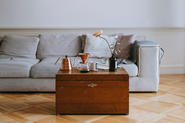 Living room with a gray couch and a wood coffee table with a coffee maker on it