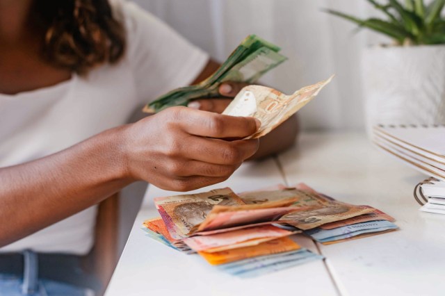 Person stacking foreign currency bills