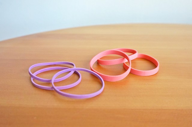 Two stacks of rubber bands, one purple and the other pink