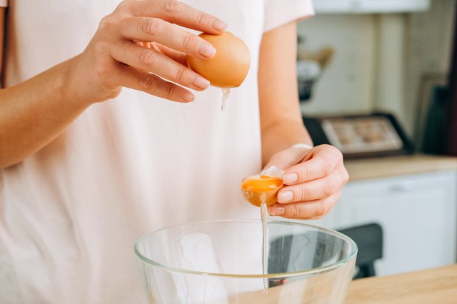 Person cracking eggs over a bowl