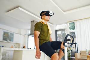 Man on exercise bike while wearing a VR headset